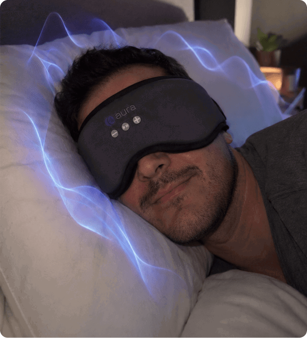 Person relaxing in bed wearing the Aura Sleep Mask