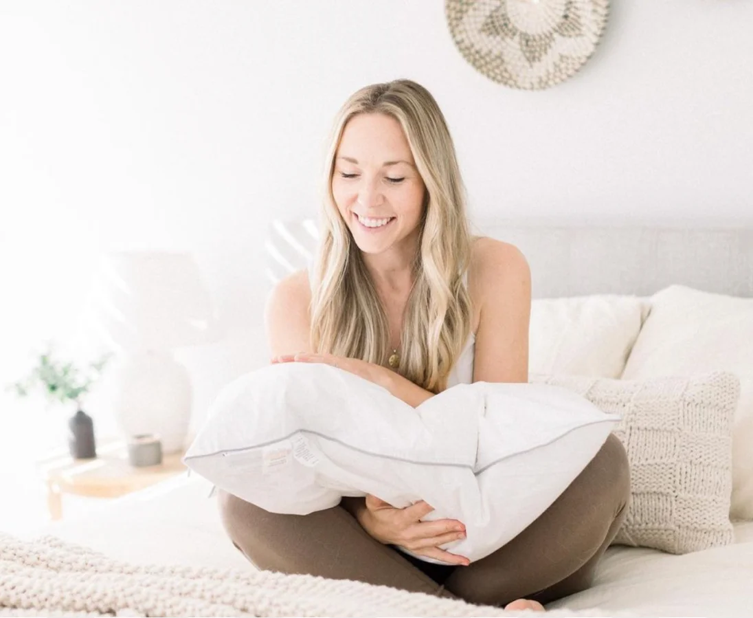Woman relaxing in bed with FluffCo pillow