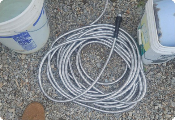 Garden Maestros Elite Metal Hose coiled outside