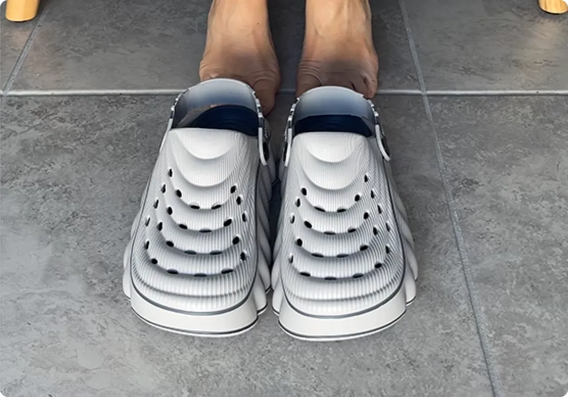Feet in Restore Clogs in Grey Pebble on a tiled floor