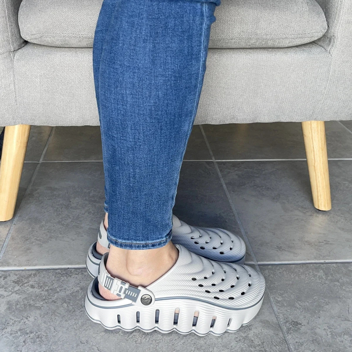 Restore Clogs in Grey Pebble, worn while sitting in an armchair