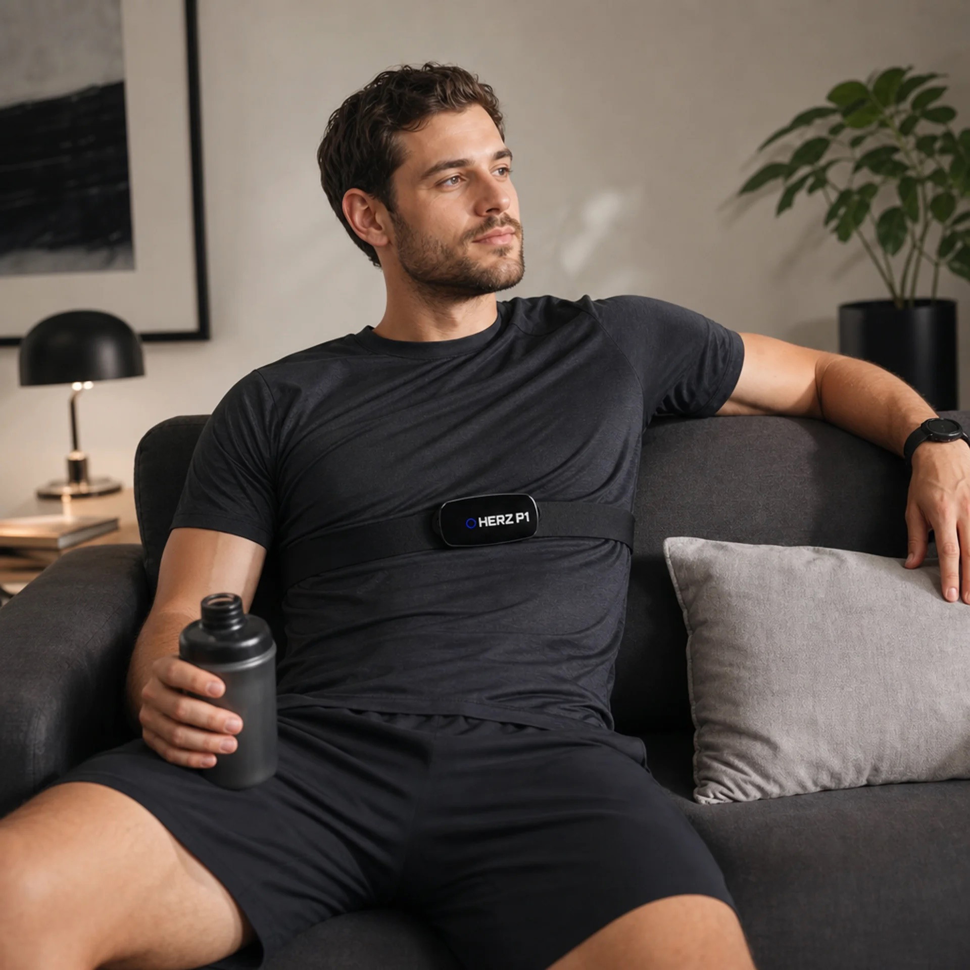 Man relaxing on a couch at home wearing the Herz P1 chest strap