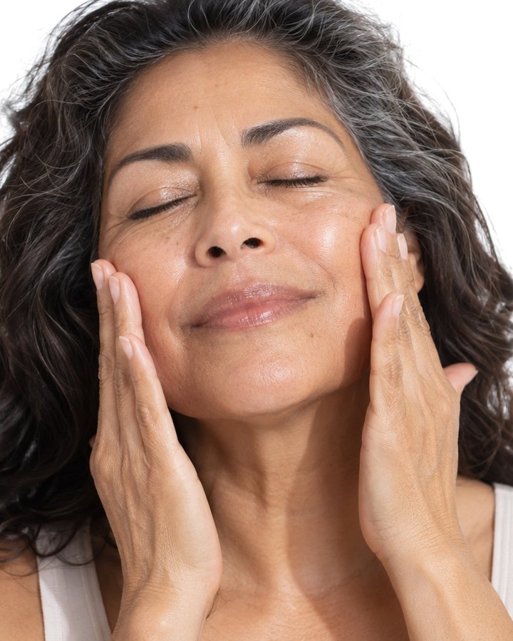 A woman pressing the serum into her cheeks