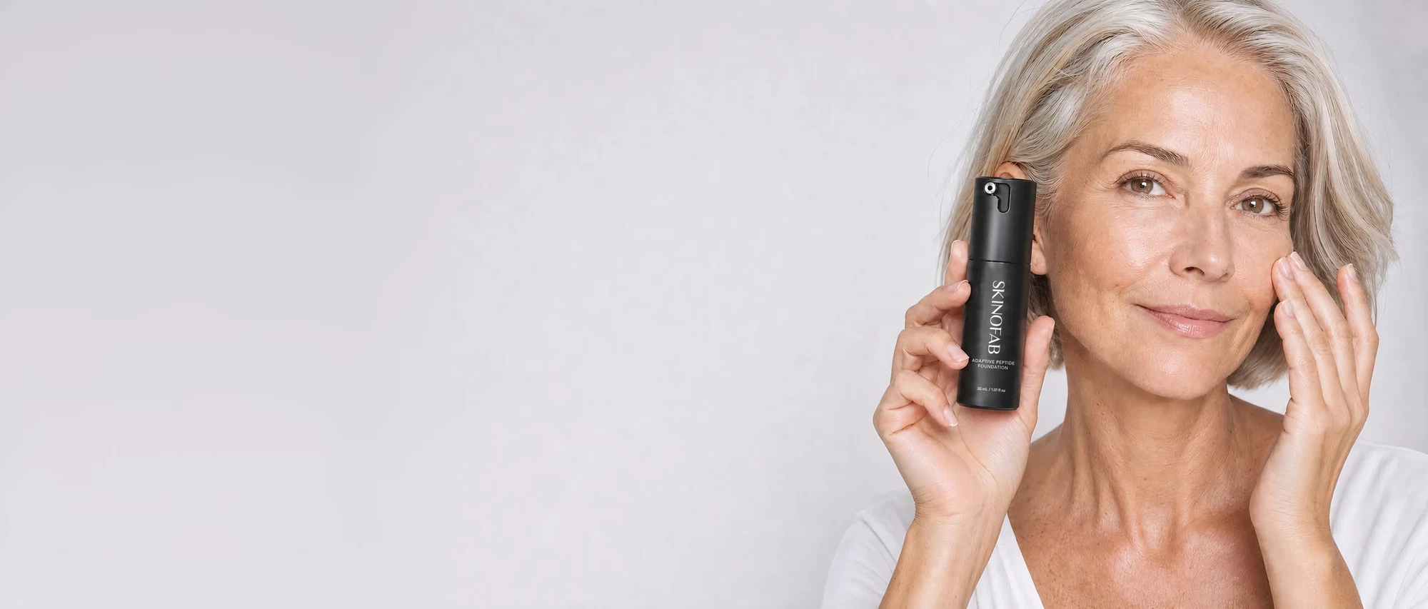 A woman in her fifties holding the Adaptive Peptide Foundation
