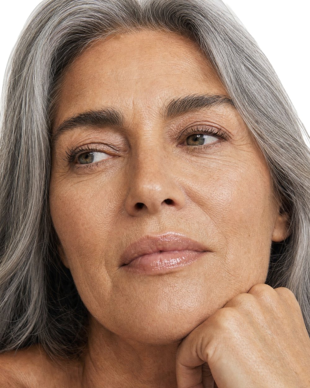A woman in her late fifties looking at her skin