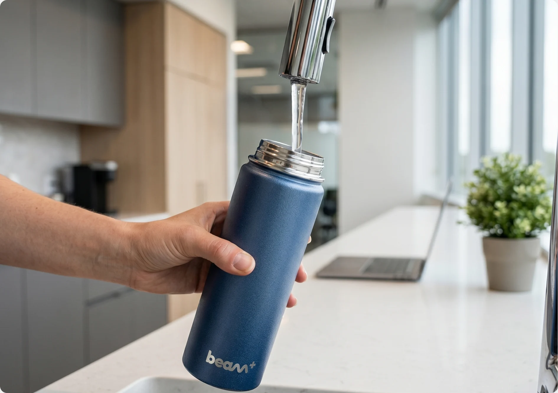 Beam+ bottle being filled at an office kitchen tap