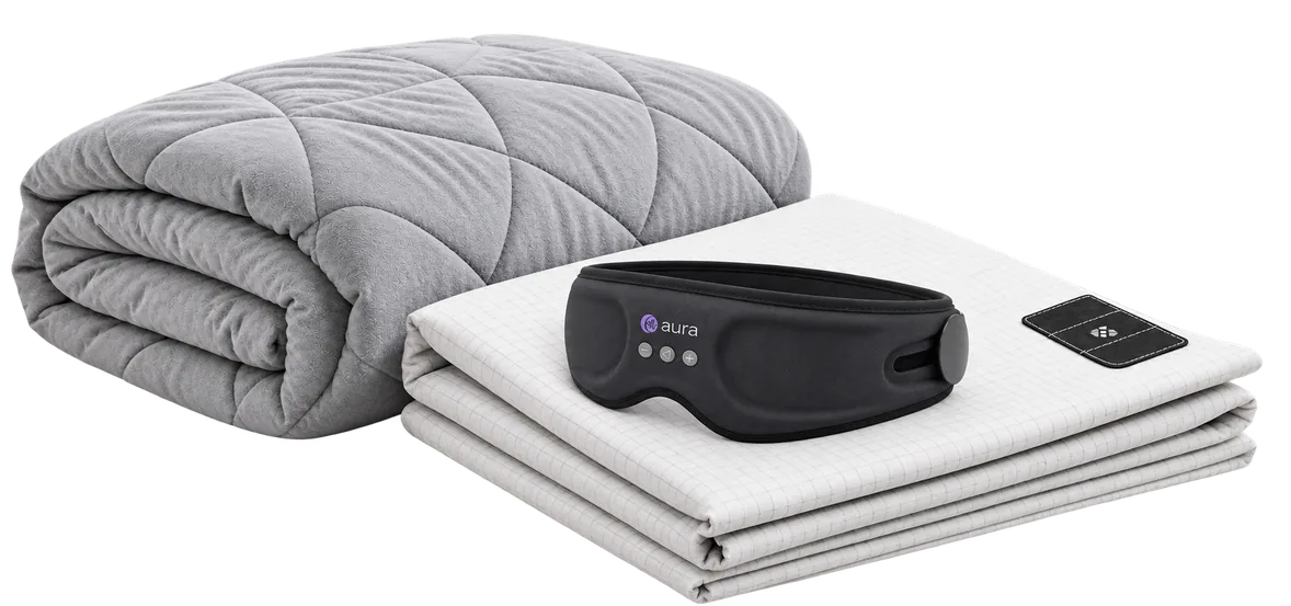 The Stillweight blanket, an Equilibrium sheet and the Aura sleep mask together on a bed