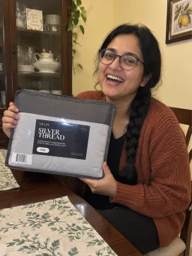 Customer smiling with her Velin Silver Thread sheet set