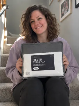 Customer holding a Velin Silver Thread sheet set