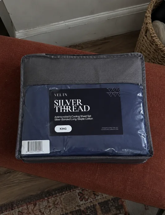 Velin Silver Thread sheet set resting on a sofa