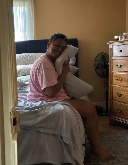 Customer sitting on a bed made with Velin sheets