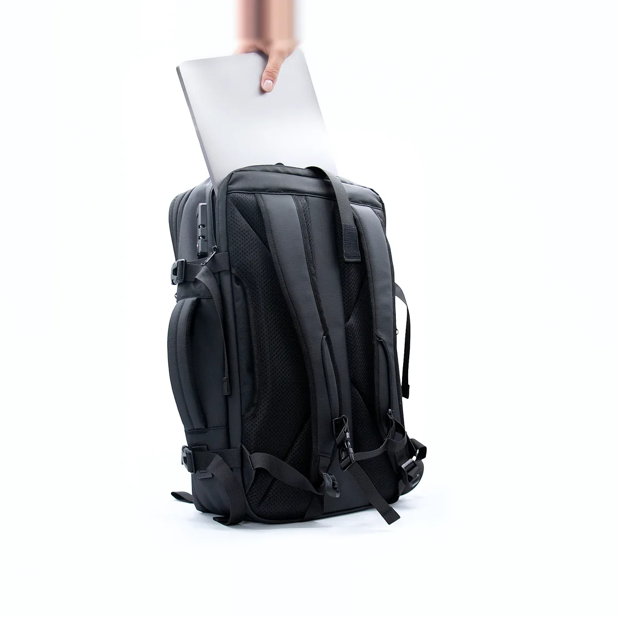 A laptop sliding into the Voyge Backpack's padded sleeve