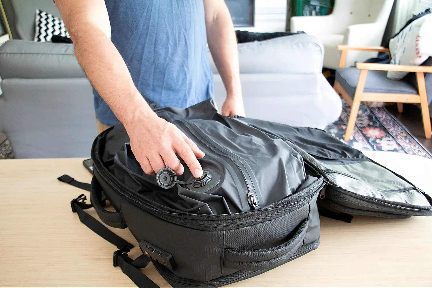 A hand pressing the built-in pump button on the compression bag
