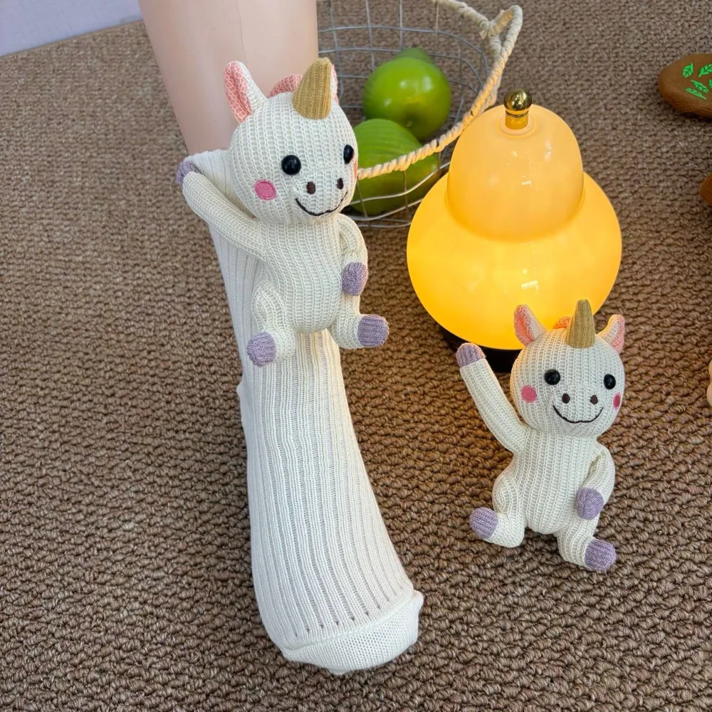 Unicorn socks worn while relaxing with a warm drink