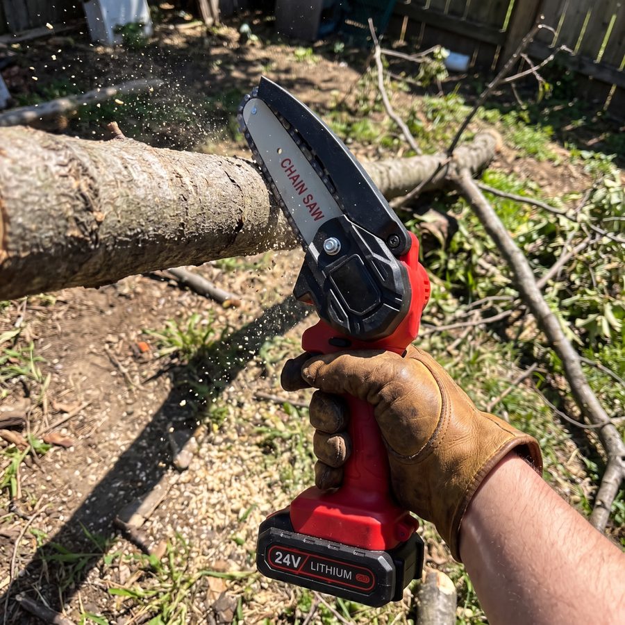 Cutting a backyard tree branch with the WOODRANGER Mini Chainsaw