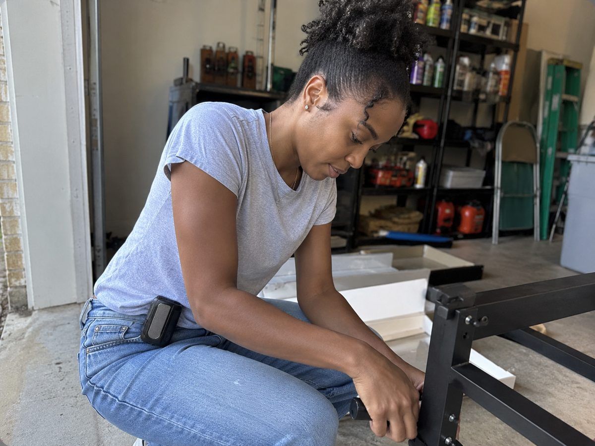 Woman building furniture in a garage with the Arctic Clip on her jeans