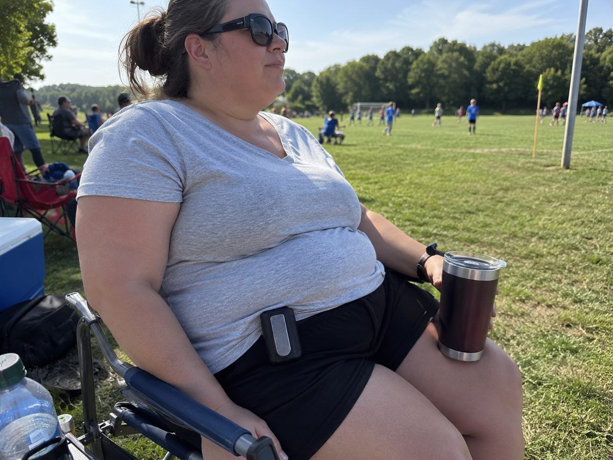 Woman in a camp chair at a soccer game wearing the Arctic Clip