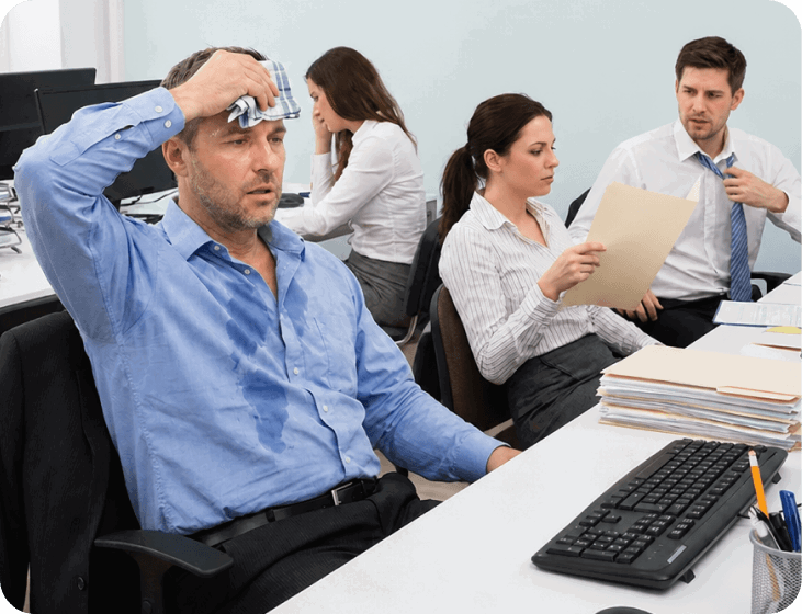 Man sweating at a warm office desk