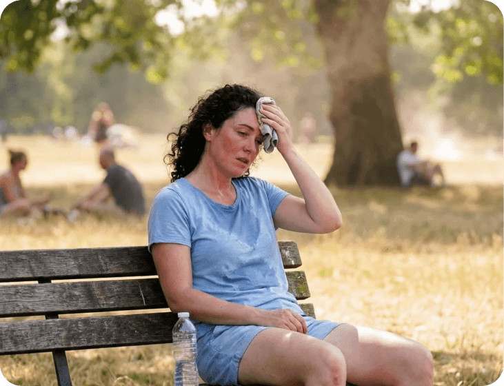 Woman resting on a park bench in the heat